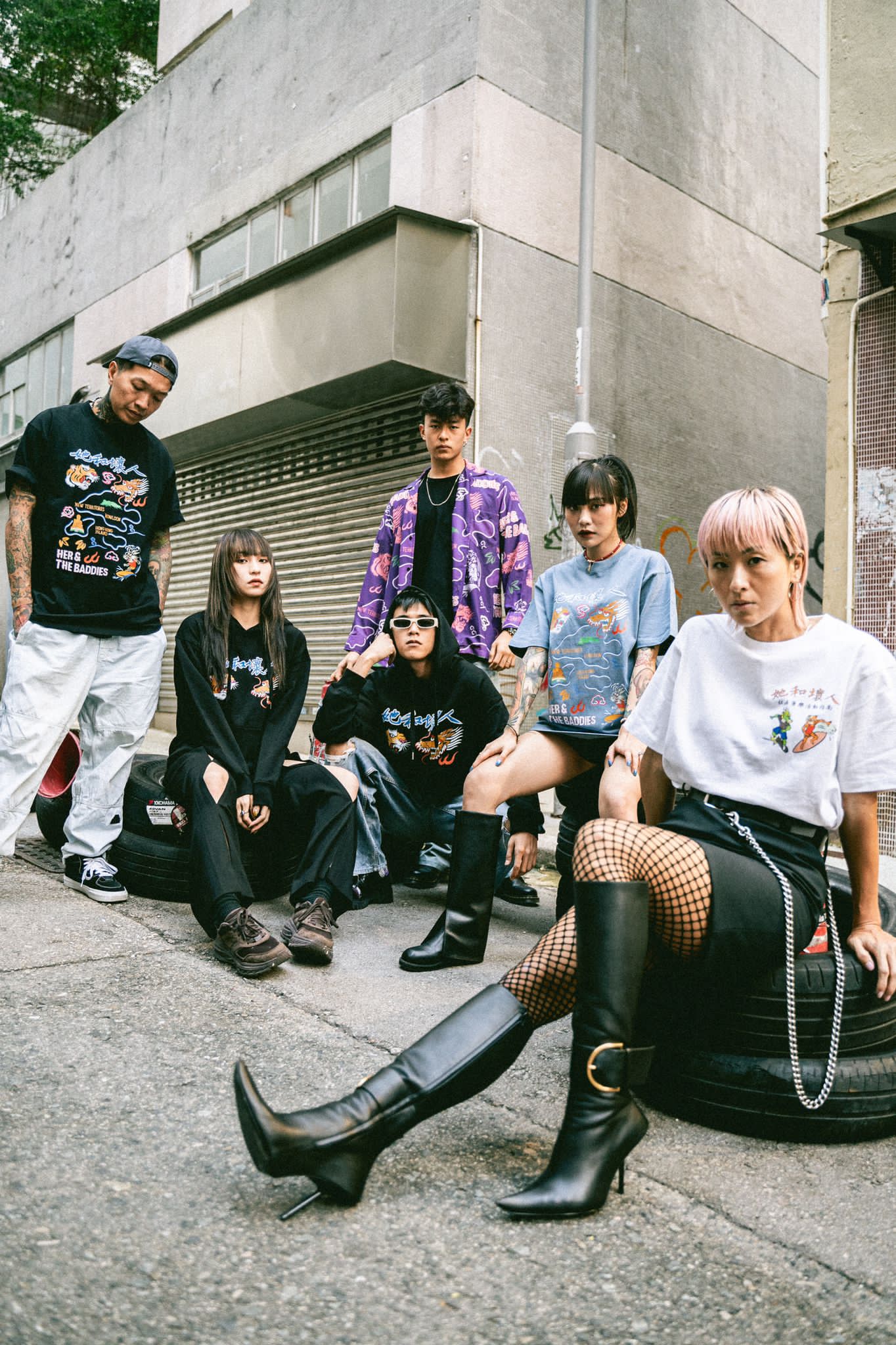 Dragon Made 8 lookbook — the range worn on a Hong Kong back street, sitting on tyres against a graffitied shutter